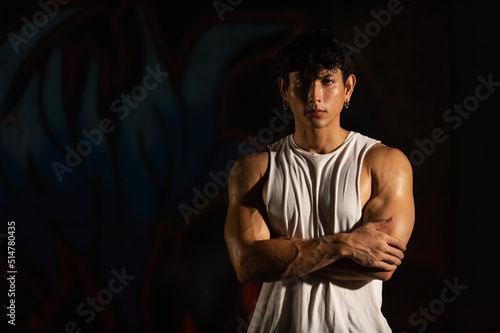 Portrait of Strong Asian sportsman athlete do sport training workout exercise bodybuilding in abandoned building. Active man bodybuilder practicing muscular strength training in dark old gym