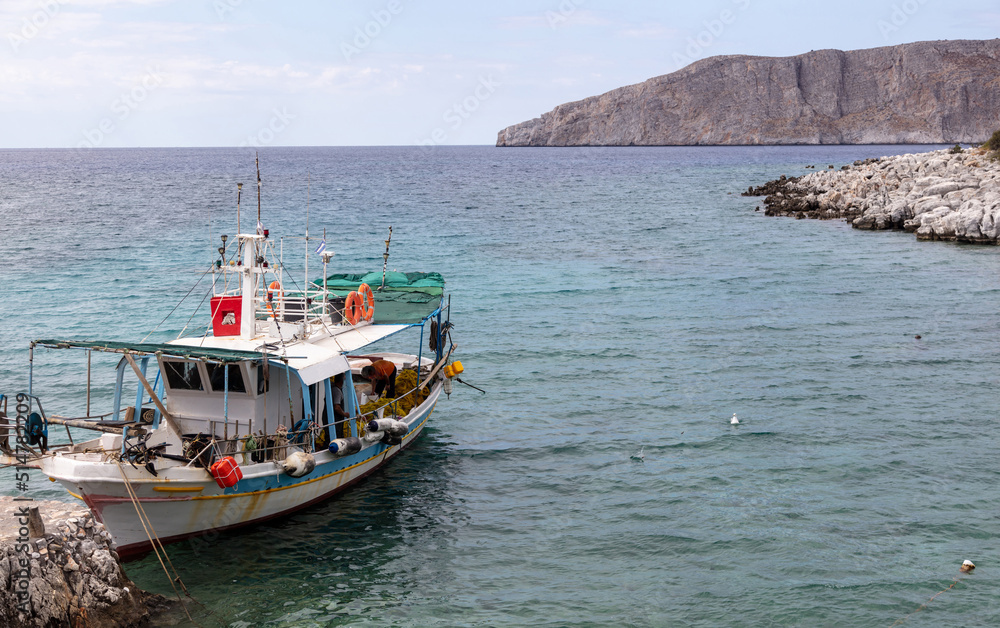 Greece. Gerolimenas village, Mani Laconia, Peloponnese. Fishing boat in calm sea.