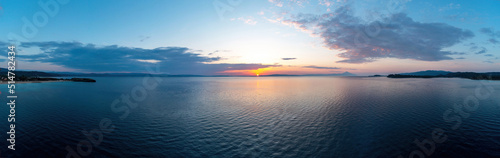 Sunrise over calm ocean aerial panorama. Sunset orange and blue color cloudy sky. Chalkidiki, Greece © Rawf8