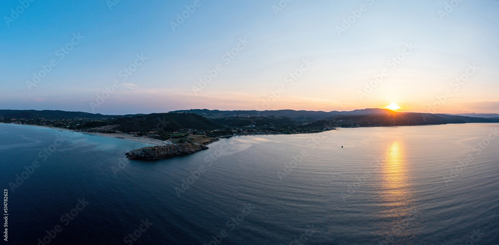 Sunrise over calm ocean aerial drone view. Ormos Panagias, Sithonia, Chalkidiki, Greece.
