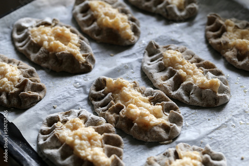 Homemade karelian pies (fin: karjalanpiirakka) - traditional Finnish snack including rye bread shell filled with boiled rise. Delicious savory food often eaten with some egg butter. Color closeup.
