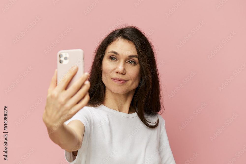 portrait of a beautiful emotional woman with a fashionable phone in her hands takes a selfie with her hand outstretched forward portrait of a beautiful emotional woman with a fashionable phone in her hands takes a selfie with her hand outstretched forward