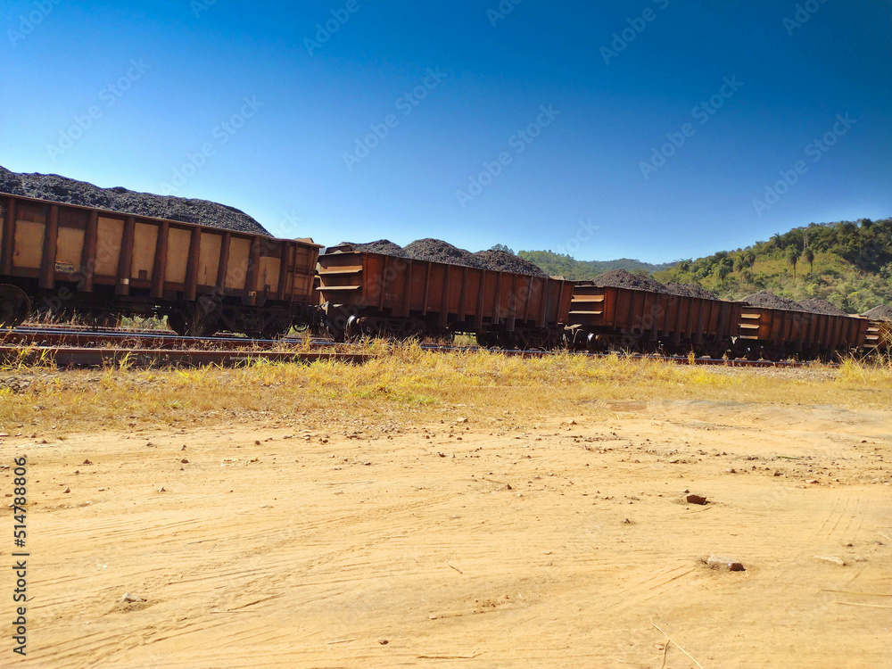 Landscape showing ore cargo train car , mountains, hill and clean blue sky background at Itabira Minas Gerais, Brazil Landscape showing ore cargo train car , mountains, hill and clean blue sky background at Itabira Minas Gerais, Brazil