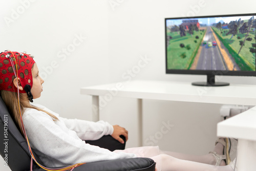 Girl with headgear to monitoring the brain activity during a biofeedback session