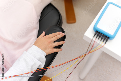 Relaxed arm of a patient connected to a device during a biofeedback session