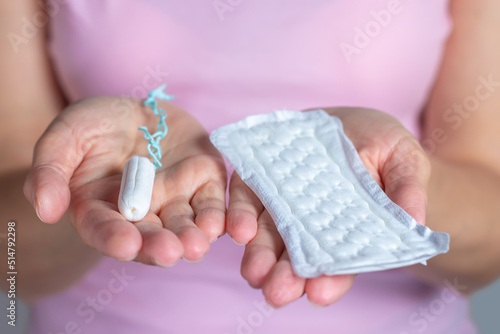 Woman holding a menstruation cotton tampon and gasket in her hand. Hygiene and protection