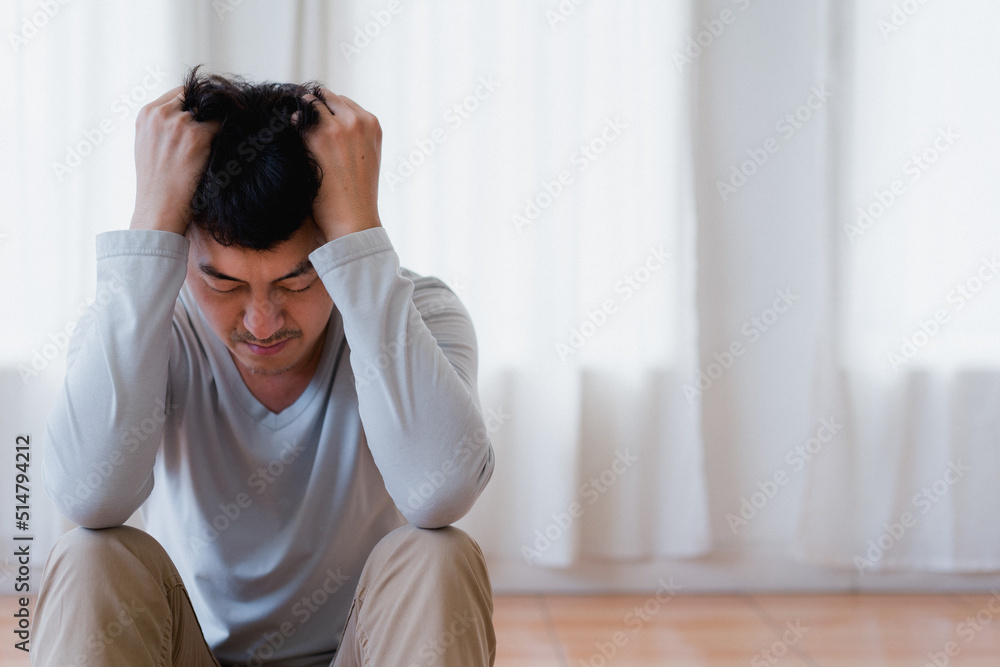 person with headache , Depressed asian young man covering face by hands, crying alone at home, upset man sitting , feeling unhappy after quarrel or breakup, despair and lonely and panic , psychologic person with headache , Depressed asian young man covering face by hands, crying alone at home, upset man sitting , feeling unhappy after quarrel or breakup, despair and lonely and panic , psychologic