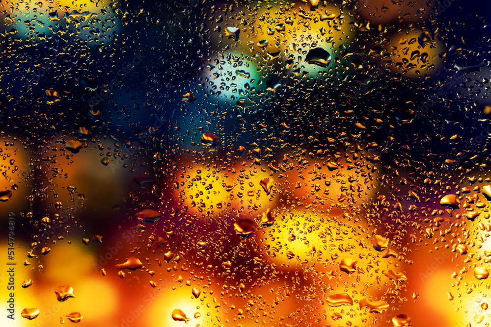 Water drops and condensation in a window glass. Abstract background niglt light