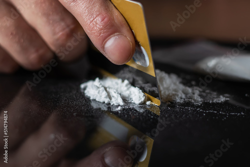 Slika na platnu Man use credit card to make cocaine drug powder lines on black table