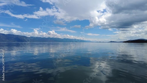 Beautiful dramatic summer cloudscape over Flathead Lake in Montana on calm June day 4K.