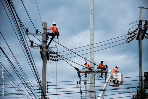 Electricians are climbing on electric poles to install and repair power lines.