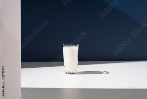 Un vaso de leche fresca de vaca sobre fondo azul	