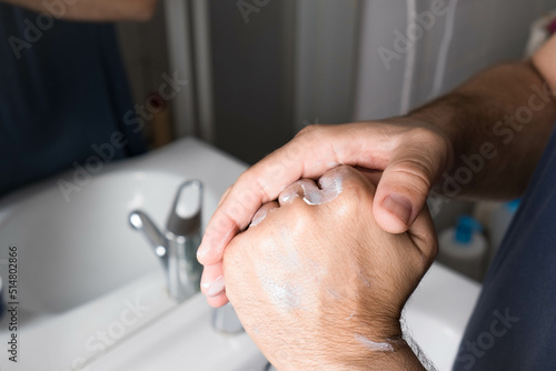 Photography Close-up of a man's hands applying cream. male cosmetics