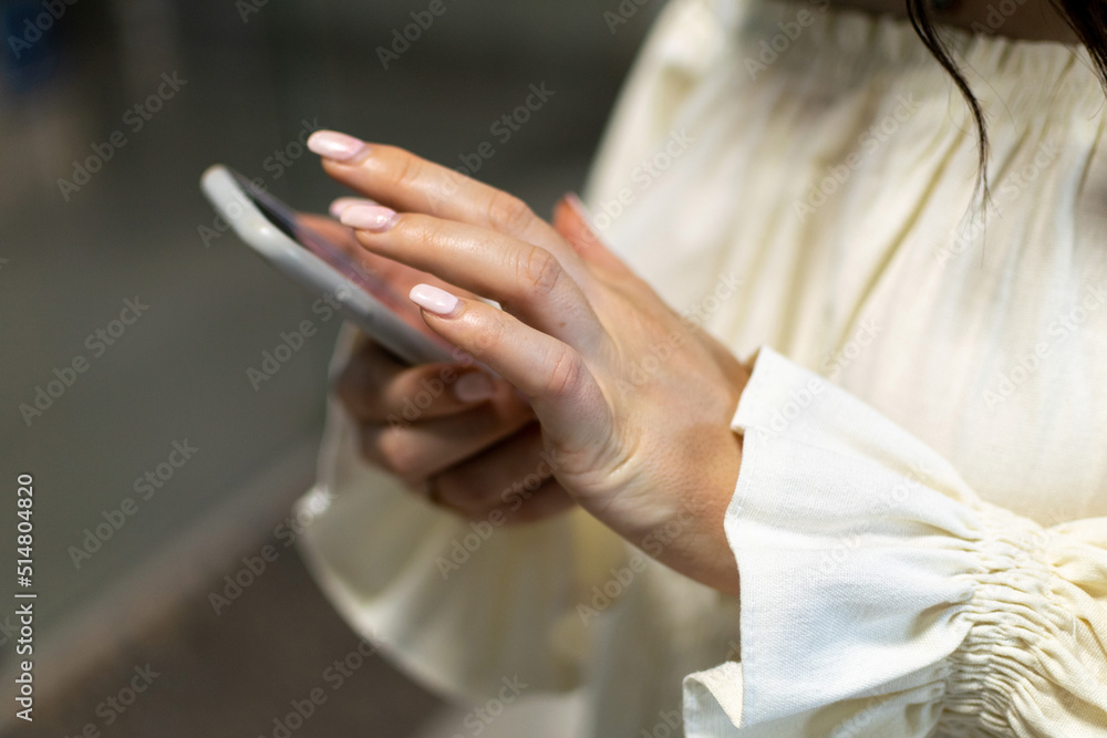 Female hands holding a cell phone. Woman hand holding the smartphone. Girl shows finger