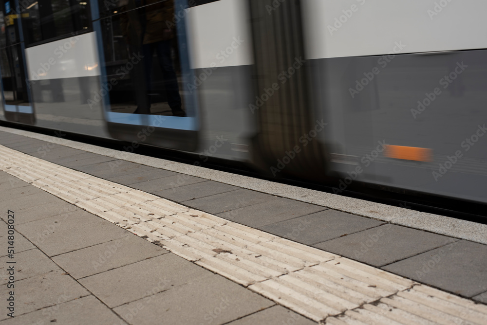 a modern streetcar is passing the stop