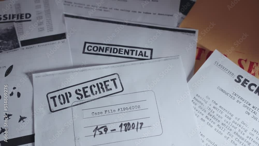 Secret Papers Example Hand setting down top secret paper on desk along side other classified ...