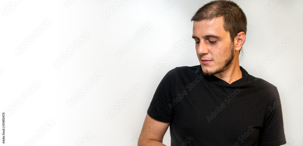 Boy on a white background. Caucasian white man with short hair, little beard and dark eyes. Reading promo text on copy space. Boy on a white background. Caucasian white man with short hair, little beard and dark eyes. Reading promo text on copy space.