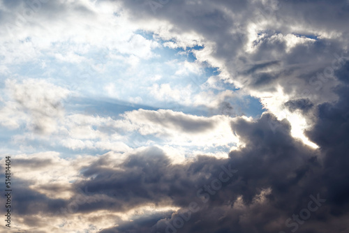 Rays of the sun through thunderclouds. Blue sky. Before a storm or thunderstorm.