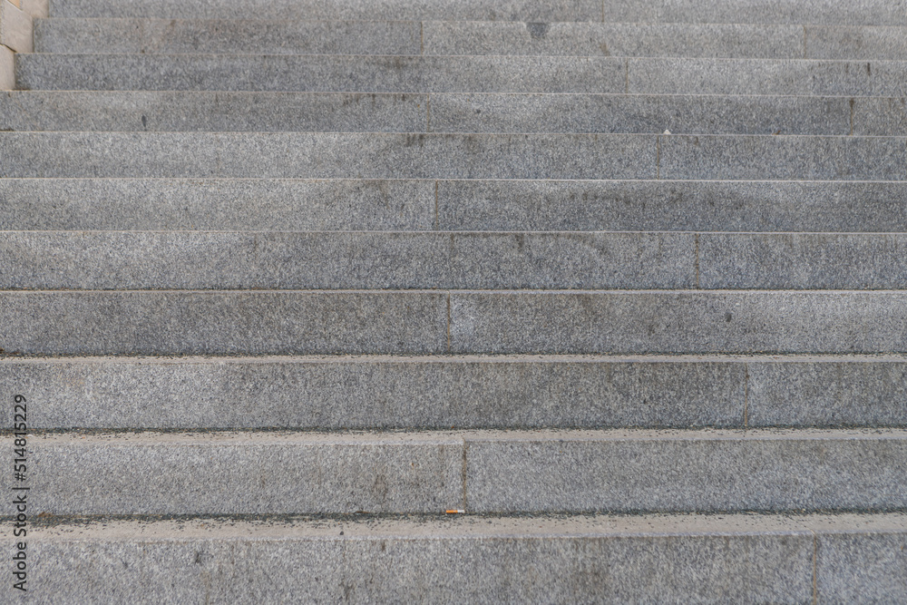 Granite stairs going up. There is trash on the stairs. Granite stairs going up. There is trash on the stairs.