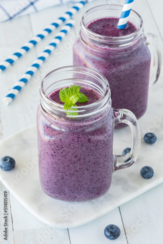 Two jar mugs filled with a healthy blueberry smoothie.