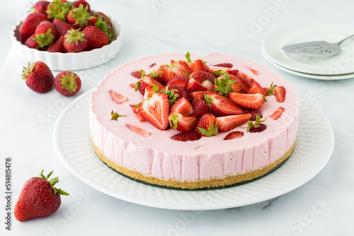 Close up of a whole strawberry cheesecake ready for serving.