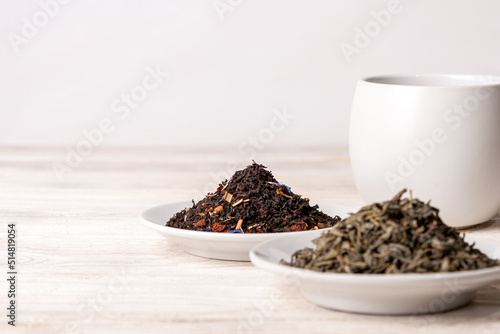 varieties of black and green tea on a white background  selective focus  copy space