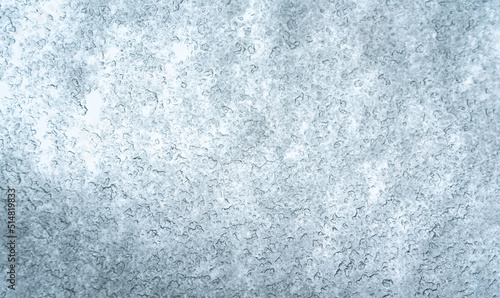 Snow creating texture on the glass. Structure of snow flakes and ice crystals melting on the window glass, winter background. Winter weather. © PhotoRK