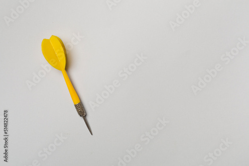 Yellow darts on color background, top view