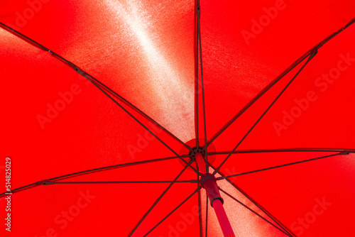 Underside of a bright colorful red umbrella in sunlight