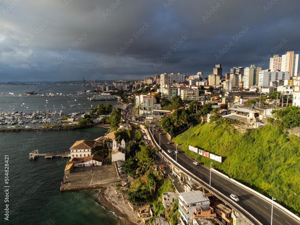 Fototapeta premium Storm clouds arriving as the setting sun illuminates the city of Salvador