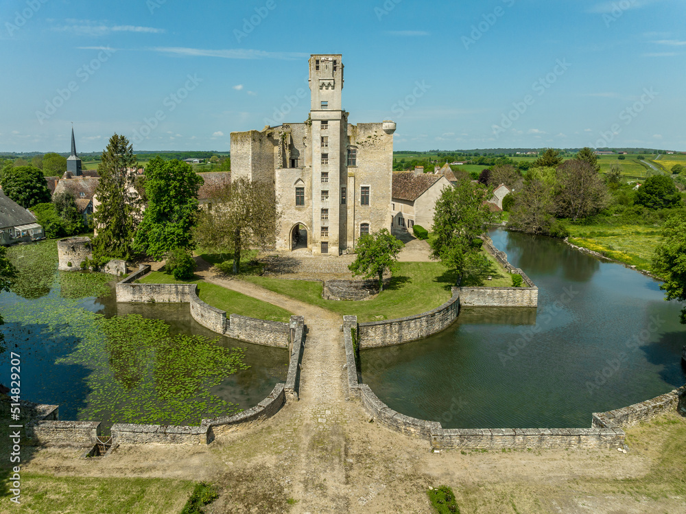 Aerial panning view of Sagonne castle in France with inner complex surrounded by an outer wall strengthened by circular towers, moat filled with water