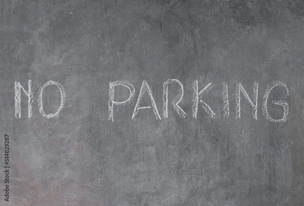 Fototapeta premium Cement wall with no parking sign written in chalk