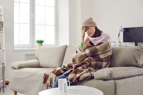 Canvas Print Sick woman who has fever looks frustrated at thermometer which again shows high temperature