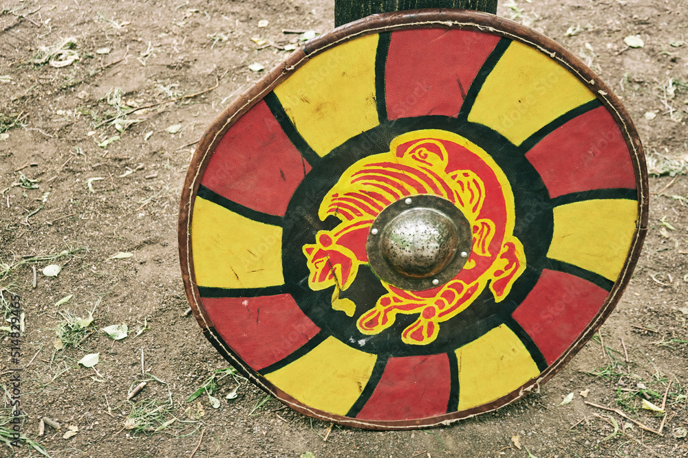 Red vintage shield with yellow animal lion a medieval warrior. Reconstruction of the events of the Middle Ages in Europe