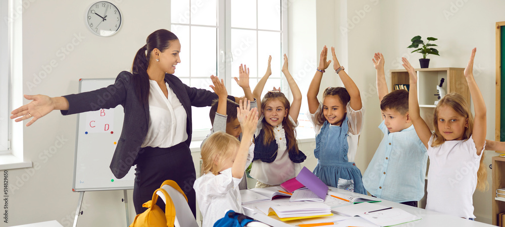 Cheerful teacher and students having fun in class. Happy young woman ...