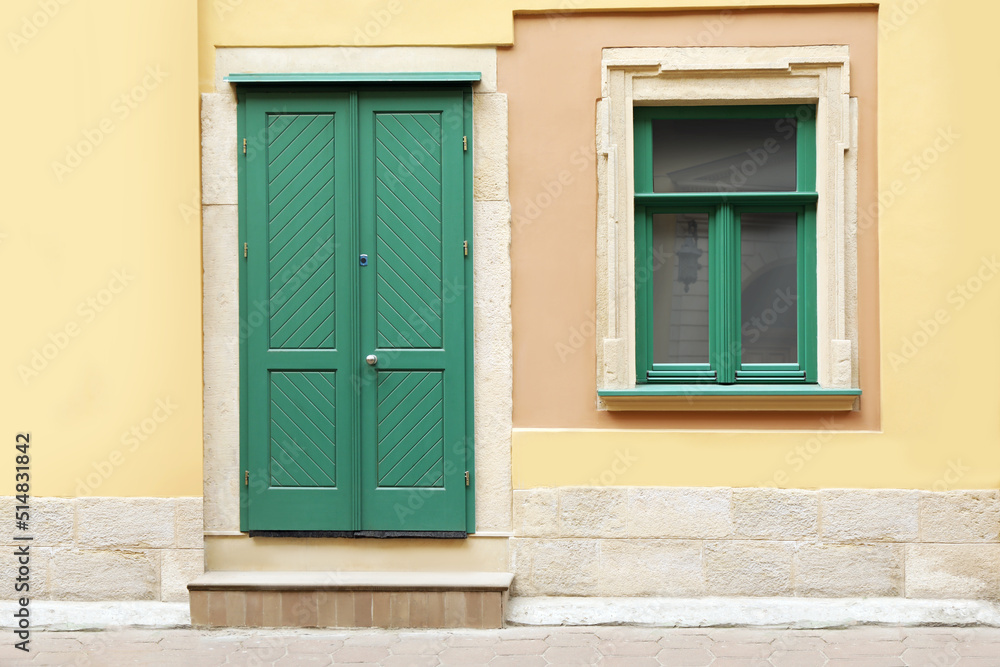 View of building with turquoise wooden door and window. Exterior design View of building with turquoise wooden door and window. Exterior design