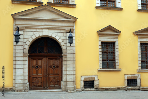 View of house with beautiful arched wooden door and grated windows. Exterior design