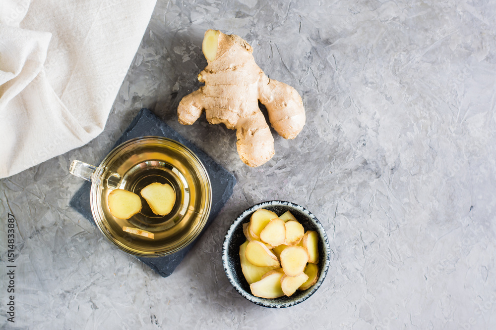 Ginger tea in a cup and chopped root in a bowl on the table. Natural Vitamins. Top view Ginger tea in a cup and chopped root in a bowl on the table. Natural Vitamins. Top view