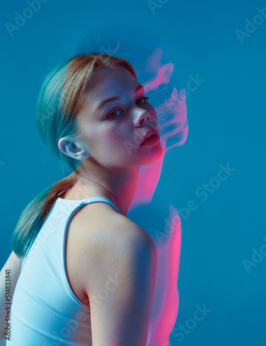 Beauty portrait of modern young girl wearing white top in pink neon light with long exposure. Nightlife, youth culture