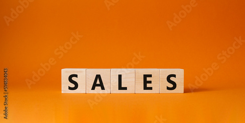 Sales symbol. Concept word Sales on wooden cubes. Beautiful orange background. Business and Sales concept. Copy space.