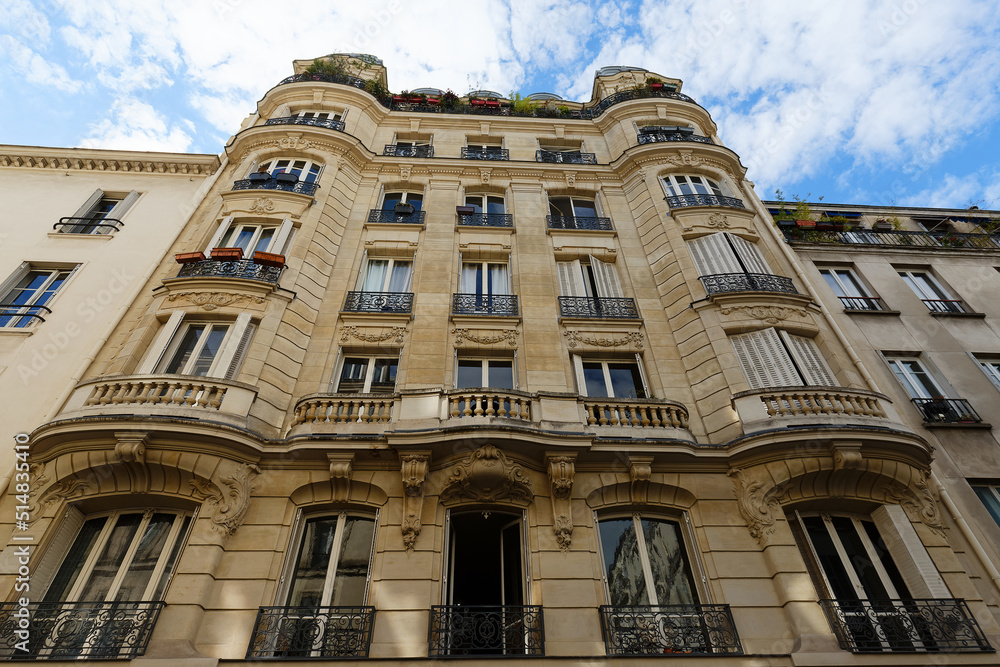 Obraz premium The facade of traditional French house with typical balconies and windows. Paris.
