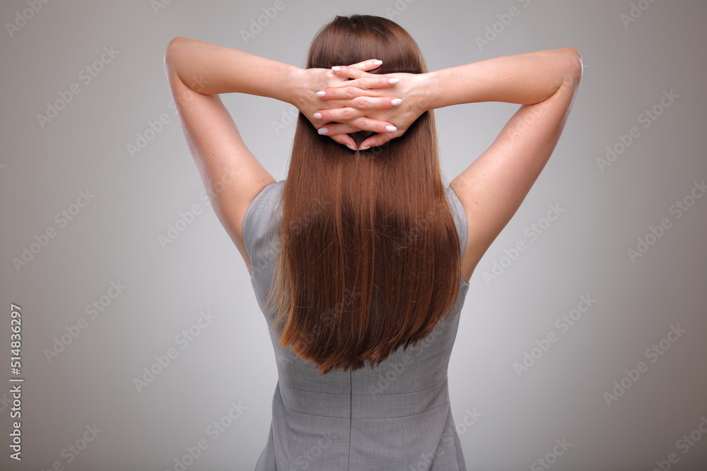 Isolated business woman back view portrait with folded hands on neck, business person, teacher or adult student with long hair. Isolated business woman back view portrait with folded hands on neck, business person, teacher or adult student with long hair.