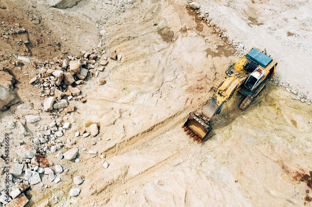 Aerial photo of excavator on industrial place. Industrial site top view. Shooting from the drone.