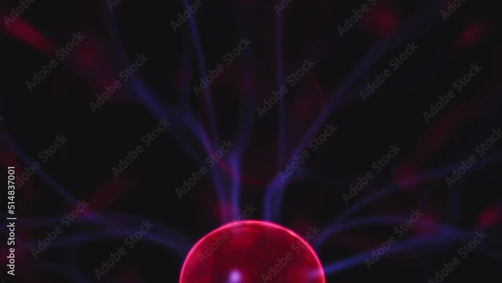 Plasma globe lamp glowing in dark at night. Electric lightning bolts moving. Magical light. Electricity, tech, science Plasma globe lamp glowing in dark at night. Electric lightning bolts moving. Magical light. Electricity, tech, science
