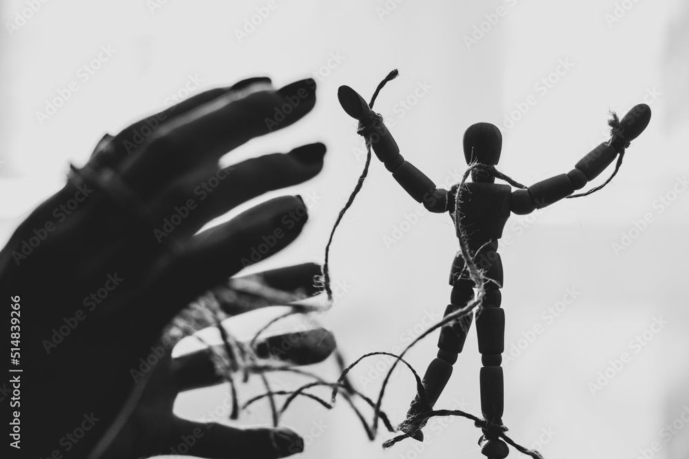 Wooden puppet tied with ropes to the puppeteer, manipulation of people, people are slaves, propaganda - obrazy, fototapety, plakaty 