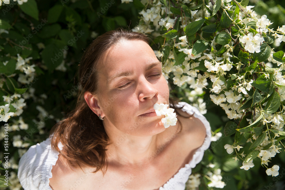 little girl holding and inhaling jasmine scent amid flowering jasmine bushes in garden in summer. Aromatherapy and Spa concept.natural eco product. stress relief little girl holding and inhaling jasmine scent amid flowering jasmine bushes in garden in summer. Aromatherapy and Spa concept.natural eco product. stress relief