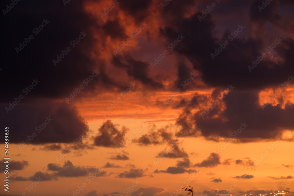 Abendhimmel - wunderbarer Sonnenuntergang mit dichten schwarzen Wolken und einer kleinen Antenne