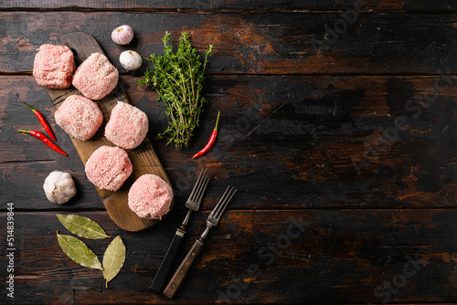 Raw ground beef meat steak cutlets, on old dark wooden table background, top view flat lay, with copy space for text