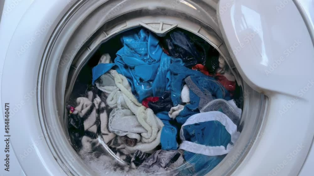Washing clothing in domestic washing machine. Close up video of spinning drum washing machine. High quality FullHD footage
Washing clothing in domestic washing machine. Close up video of spinning drum washing machine. High quality FullHD footage