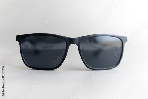 black sun glasses on gray background front view